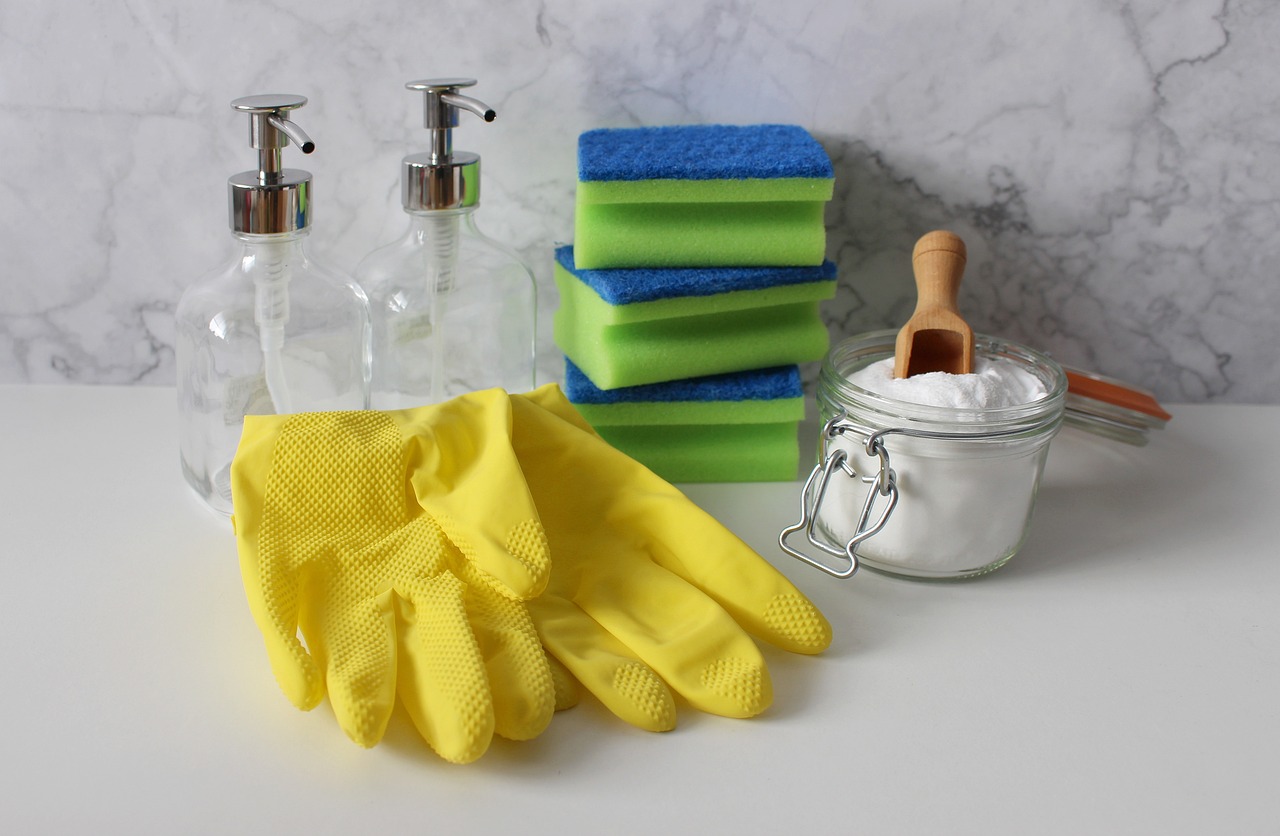 Reinigungsplan zum Reinigen von Handschuhen, Schwämmen und Reinigungsmitteln auf einer Marmorarbeitsplatte.
