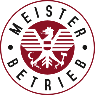 Das kreisförmige Logo in Rot und Schwarz zeigt einen Adler mit Hammer und Sichel in der Mitte. Die Worte „Meister Betrieb“ umrahmen das Design elegant und erinnern an die gründliche Präzision, mit der die Grundreinigung Graz arbeitet.